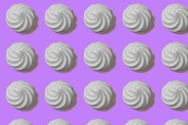 Beyaz şekerlemeler, mor arkaplandaki tatlılar.