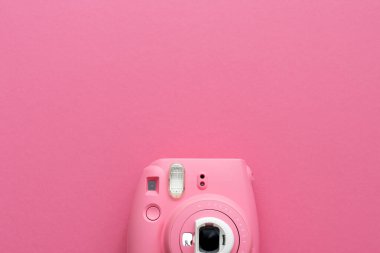 Pembe arka planda pembe hızlı baskı kamerası olan çalışma masasının yaratıcı düz yatay fotoğrafı 