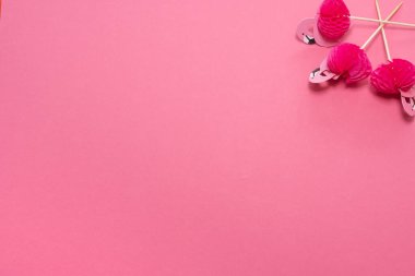 Pembe arka planda flamingo şeklinde pembe parti kürdanları. origami 