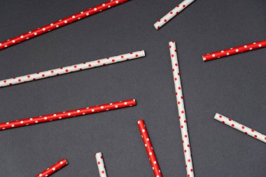 İçecekler için geri dönüştürülmüş kağıt kamış koyu arkaplanda kırmızı ve beyaz renkler