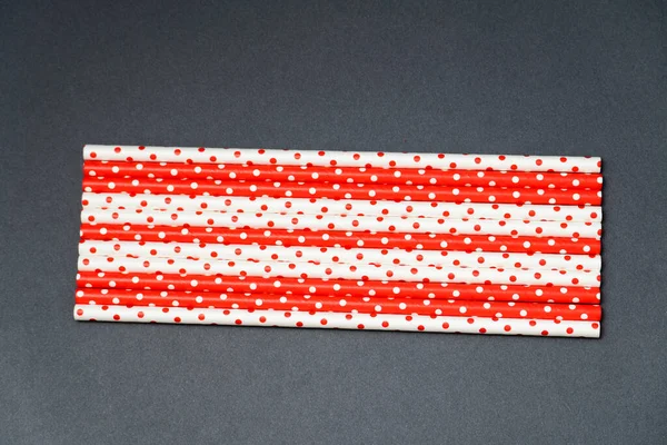 recycled paper straw for drinks red and white colours on a dark background