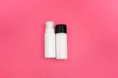 Kozmetik düz yatak: yüz kozmetik serumu, krem ve pembe arka plandaki diğer ürünler