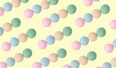 Kozmetik ürünlerinin yaratıcı desenli fotoğrafı sarı arka planda banyo bombaları.