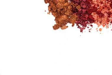 Kozmetik örneklerinin yaratıcı bir fotoğrafı. Bronz renkli kırık göz gölgeleri ve beyaz arka planda pembe renkler. 