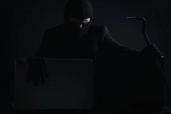 Pirata informático enojado en traje robando datos de la computadora portátil con cro —  Fotos de Stock
