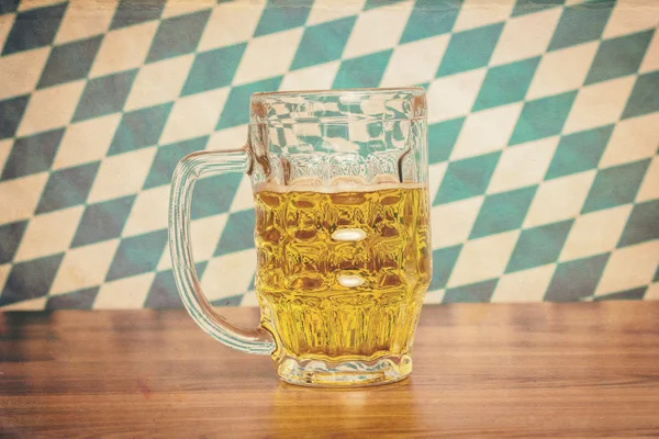 Pivo hrnek na dřevěné desce před bavorské vlajky — Stock fotografie