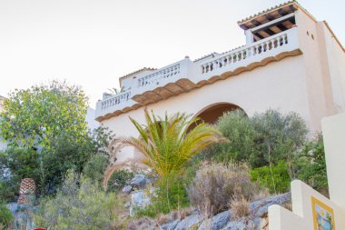 Akdeniz tatil beldesinin düşük açılı görüntüsü veya ön planda çalıları olan lüks konut