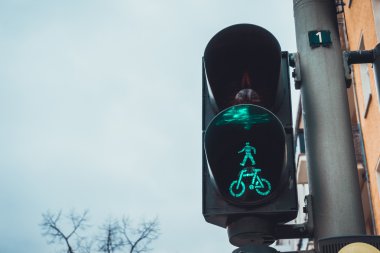 Yürüme ve Bisiklet Sembolleri Yeşil ile aydınlatılmış Yürüyen ve Bisiklet Sembolleri ile Yaya Yürüyüşü Görünümü Düşük Açı Görünümü Kopya Boşluğu ile Bulutlu Bulutlu Gökyüzüne Karşı