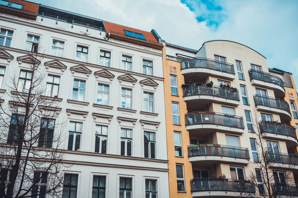 old white apartment building next to a orange newer one at berlin