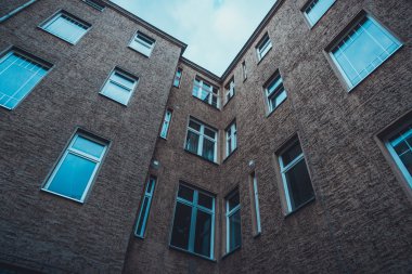 Low Rise Industrial Building 'in Düşük Açı Mimarisi Kahverengi Tuğla Cephesi, Bulutlu Gökyüzünün Altındaki Daire Daireleri