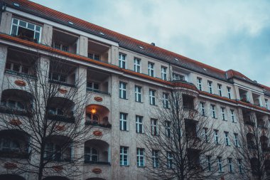 Tuğla Yüzlü ve Balkonlu Lüks Düşük Katlı Apartman Binası Mimari Dış Görünümü Kışın Çıplak Ağaçlar ve Bulutlu Gökyüzü