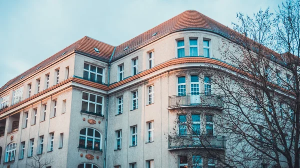 Düşük Açı Dış Görünümü Modern Lüks Low Rise Apartmanı Sunset 'te, Sıcak Güneş Işığıyla aydınlatılan ve Çerçevelenen Çıplak Ağaçlar Sonbaharın Sonlarında