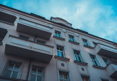 Düşük Açı Mimari Konut Binası, Balkonlu Pembe, Mavi Gökyüzü tarafından İnce Bulutlu Çerçeveli