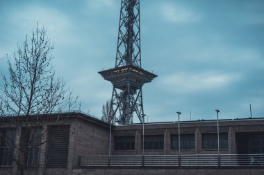 Kış boyunca koyu mavi gökyüzünün altında bir parça yüksek kule bulunan yayın binasının dışı.