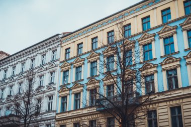 Düşük Açılı Mimari Dış Görünüm Düşük Yükseliş Konut Apartmanı Binaları Renkli Mavi ve Sarı Görünüm ve Gri Gökyüzü ve Çıplak Ağaçlarla Bulut Günü Basit Tasarım Özellikleri