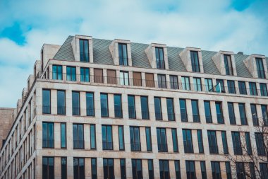 Berlin Almanya 'da modern bir apartman binasında çatı katının üstünde Dormer tarzı pencereler.