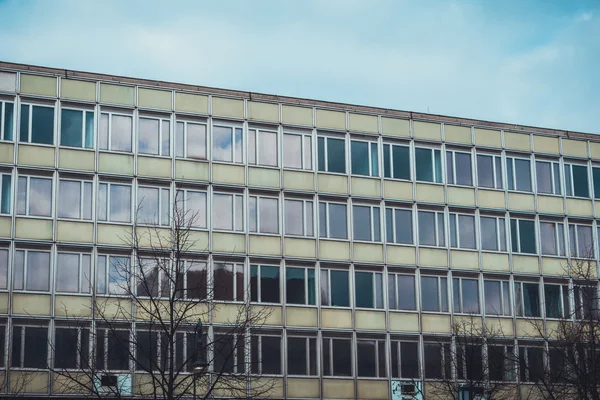 Exterior view of large post modern architectural style designed residential apartment building with tall glass windows