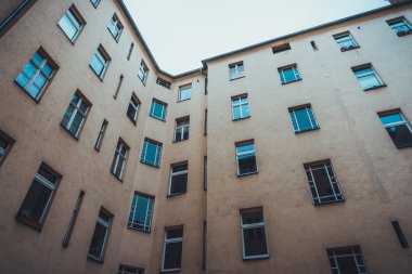 Modern çoklu katın pencerelerinin düşük açılı görüntüsü ya da gri gökyüzünün altındaki ofis binası