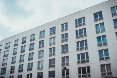 Basit beyaz cephede düşük açılı dış görünüş ve apartman veya otel binası için pencereler