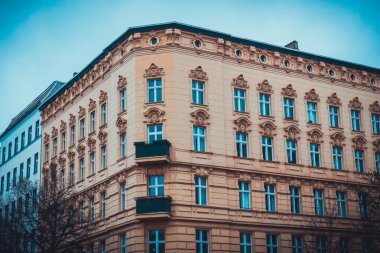 Sarı taş ve terra cotta apartmanı. Berlin Almanya 'nın sonunda küçük balkonları olan eğimli köşe yapısı var.
