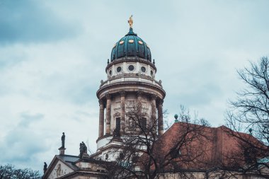 Almanya 'daki Tarihi Katedral' in Çatısı 'ndaki Kule, Kubbe ve Altın Heykel' in Mimari Dış Detayları Çıplak Kış Ağaçlarıyla çevrili ve Gök tarafından Çerçevelenmiş Şiddetli Bulutlar