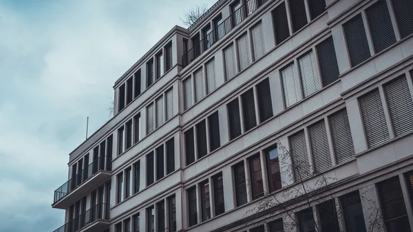 Bulutlu bir günde Berlin 'de Bulutlu Gökyüzü ile birlikte Balkonlu Modern Düşük Apartman Konutları' nın Düşük Açı Mimarisi