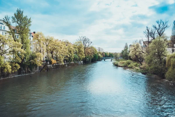 Scenic view of river meandering through a quiet town and a shore lined with trees on a sunny day