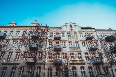 Turuncu cepheli ve mavi gökyüzlü lüks bir bina.