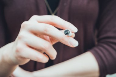 Sigara içen genç bir kadın kavramsal açıdan sigarayı tutan elini yakından görüyor.