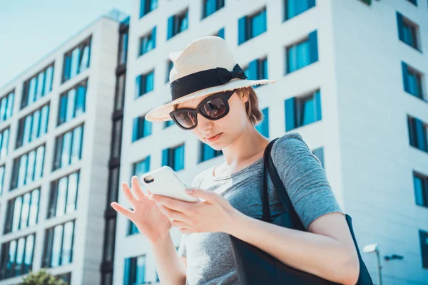 Mujer joven chic comprobando su teléfono móvil — Foto de Stock