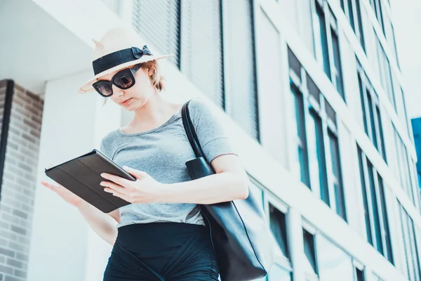 Vrouw haar tablet-pc in de buurt van gebouw controleren — Stockfoto