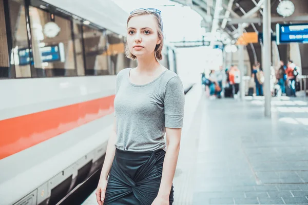 Junge Frau wartet auf einem Bahnhof — Stockfoto