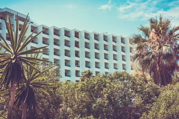 Hotel with slanted walls between palm trees — Stock Photo, Image