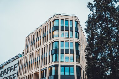 Büyük ağaç eğimli köşe ile bina önünde
