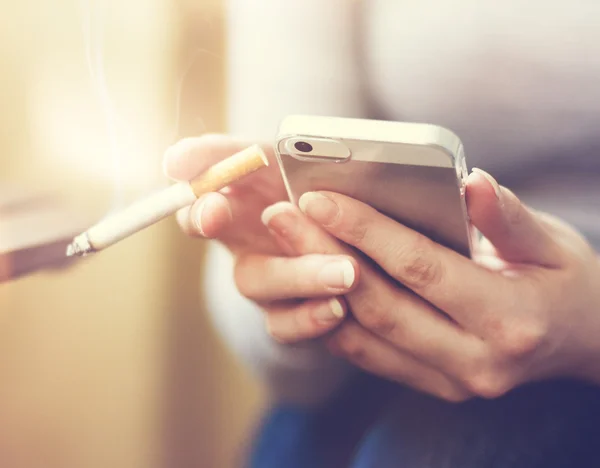 Smartphone y cigarrillo — Foto de Stock