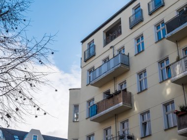 Sarı apartman çıplak ağaçlar ile