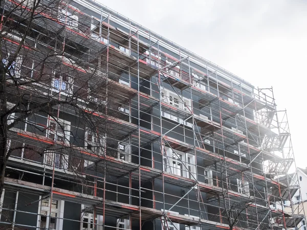 Novo edifício de apartamentos coberto com andaimes — Fotografia de Stock