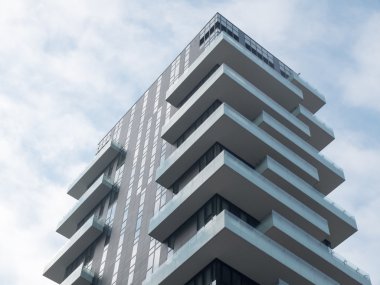 Düşük Açı Mimari Modern Konut Binası. Mavi Gök 'ün önündeki Bulutlu Büyük Gök Kaplamalı.