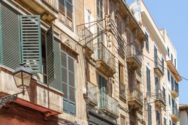 Eski apartman pencerelerinin dış görünüşü ve ona bağlı elektrik hatları.