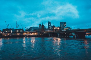 Waterfront Binaları, Thames Nehri 'ni geçen demiryolu köprüsünün görüntüsüyle aydınlandı - Bulutlu Gökyüzü, Londra, İngiltere, Uk