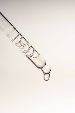 Pipetten bir damla kozmetik yağı düşüyor.