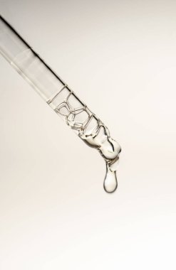 Pipetten bir damla kozmetik yağı düşüyor.