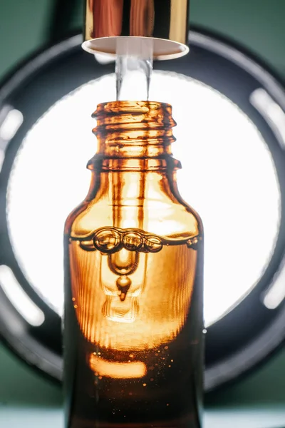 Kabarcıklı kahverengi bir şişede kozmetik yağlı boru.