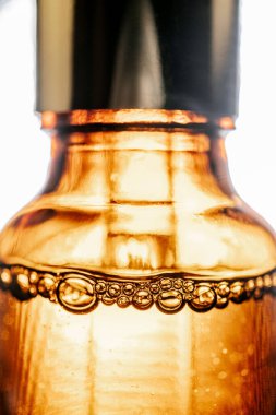 Kabarcıklı kahverengi bir şişede kozmetik yağlı boru.
