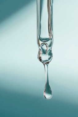 Pipetten bir damla kozmetik yağı düşüyor.