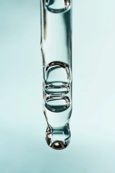 Pipetten bir damla kozmetik yağı düşüyor.