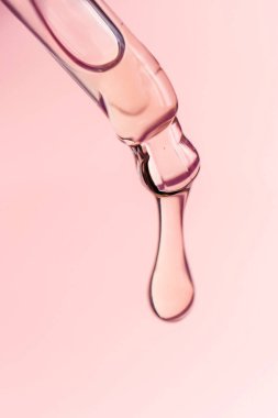 Pipetten bir damla kozmetik yağı düşüyor.