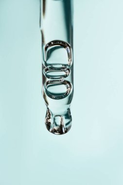 Pipetten bir damla kozmetik yağı düşüyor.