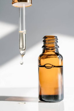 Kahverengi şişe ve kozmetik ürünlü pipet..