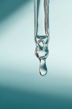 Pipetten bir damla kozmetik yağı düşüyor.